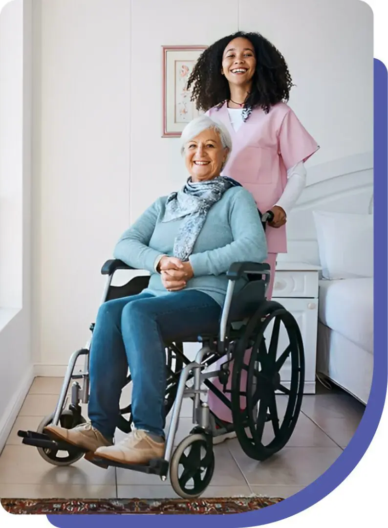 Elderly woman in wheelchair with caregiver smiling.