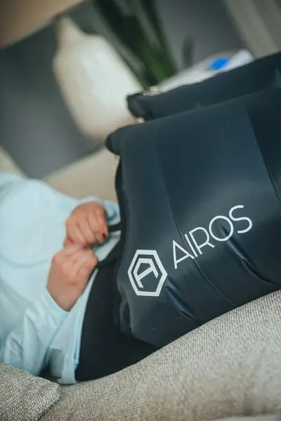 Person using Airos compression therapy device.