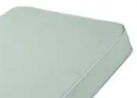 Close-up of a light green mattress or cushion corner.