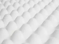 Close-up of white egg carton holding eggs in neat rows.
