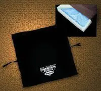 A black drawstring bag with a logo and a white box on a brown surface.