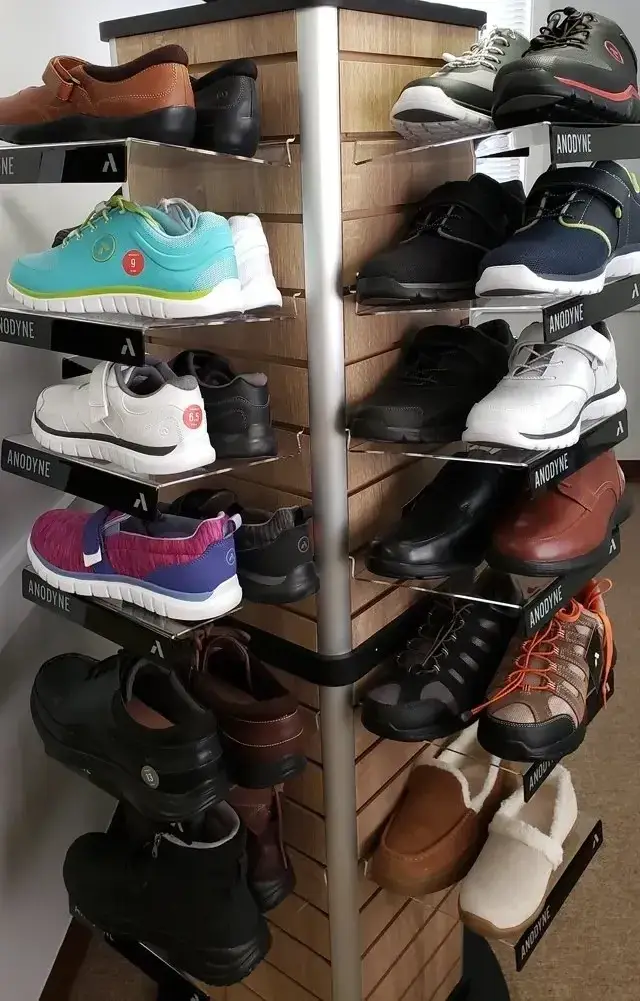 Various pairs of shoes neatly arranged on a corner shelf.