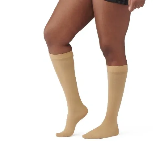 Person wearing beige compression socks on legs.
