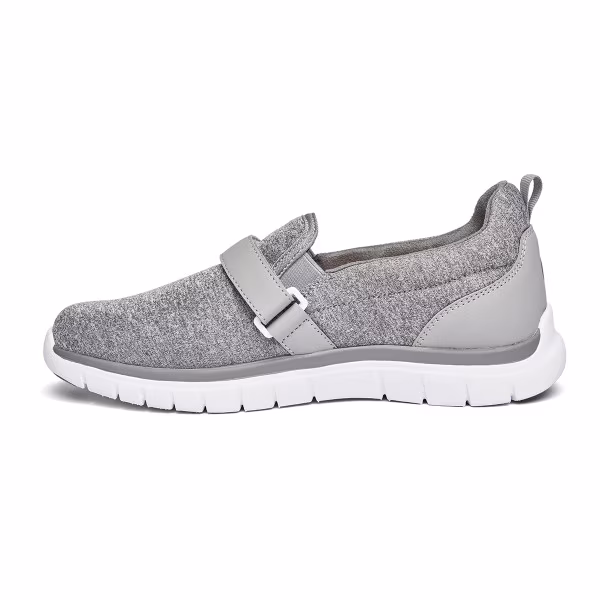 Gray slip-on sneaker with white sole and adjustable strap.