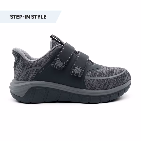 Black and grey step-in sneakers with two Velcro straps.